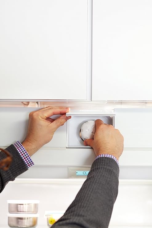Hands turning a water filter in the upper refrigerator housing on the Sub-Zero 4204490 listing